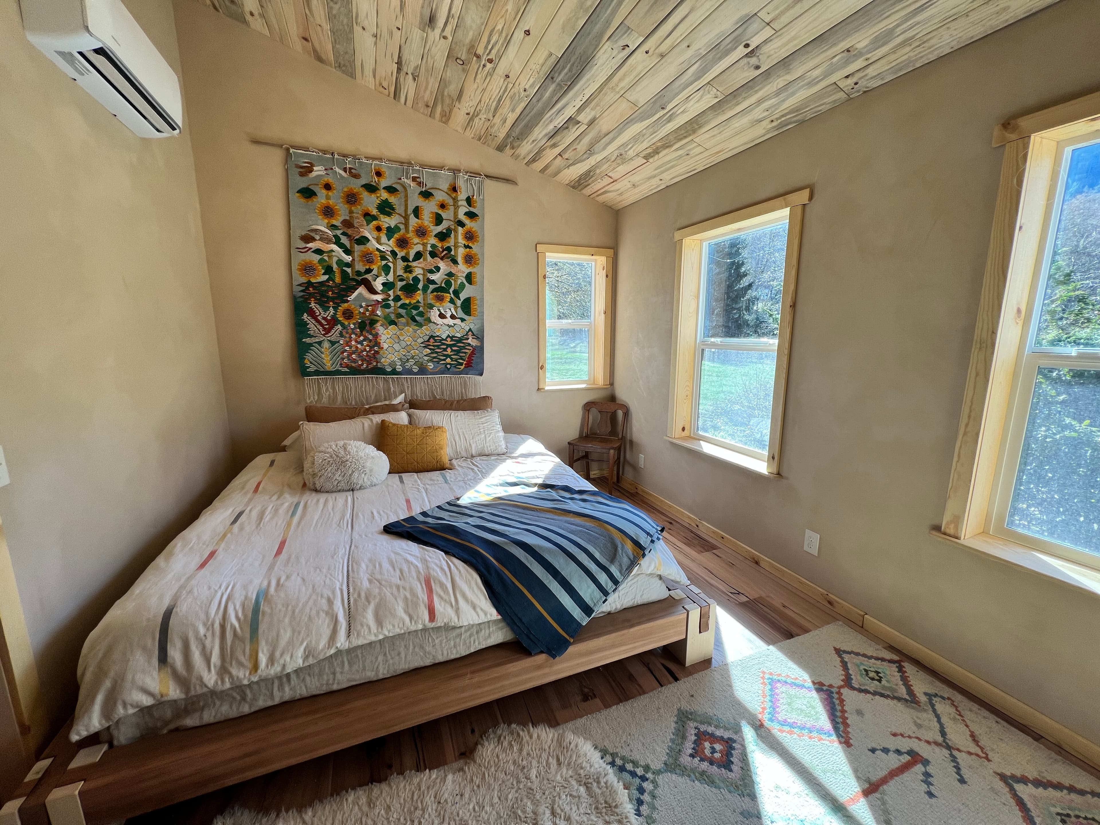 Beautiful bedroom with natural plaster walls and sunflower tapestry